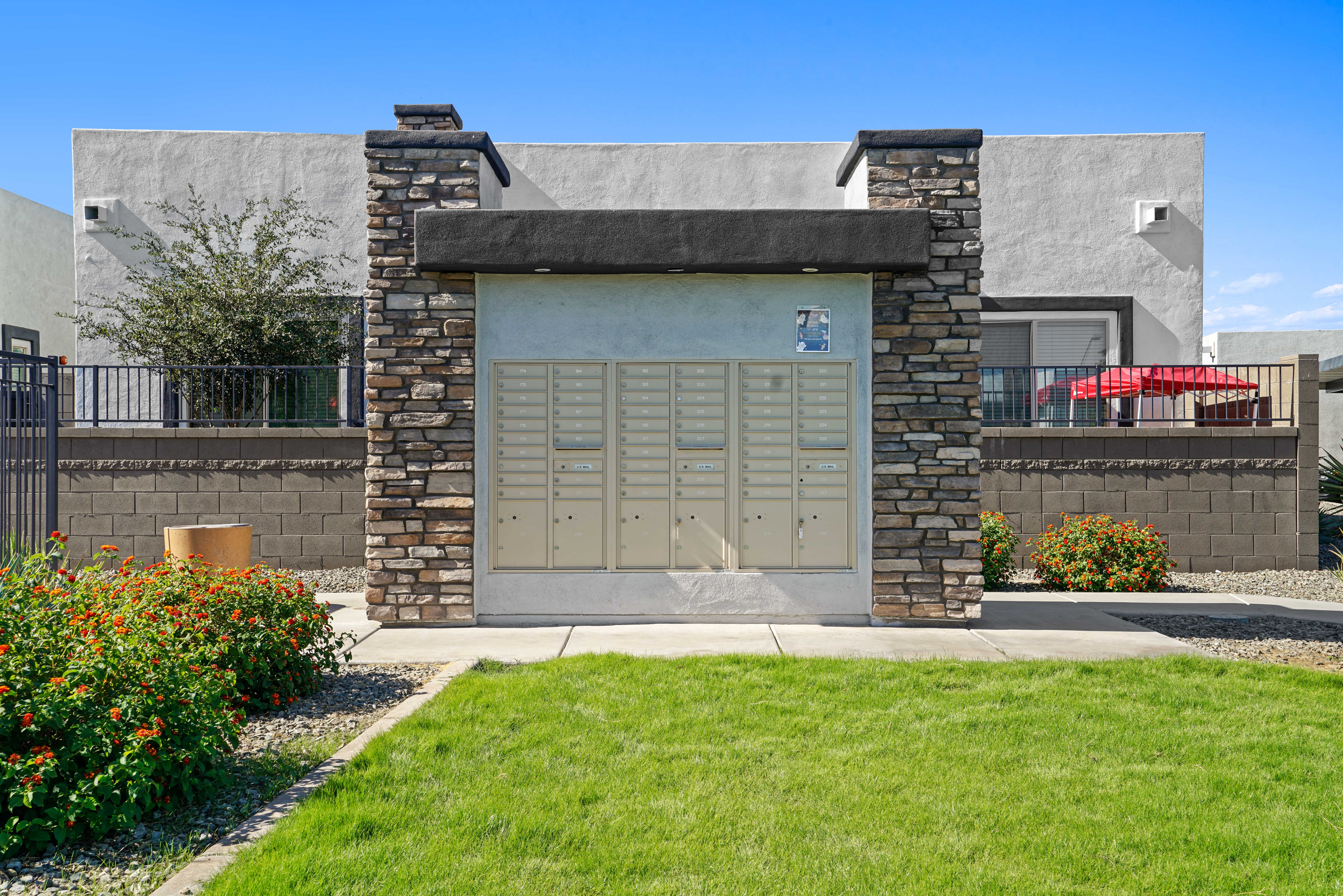 the front of a building with a garage door and a lawn at Olive Queen Creek Apartments, Arizona, 85142